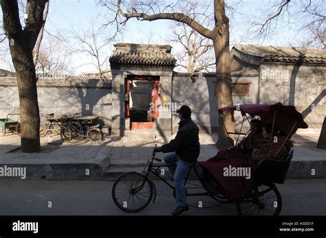 Tourists On A Hutong Tour Pass The Classical Entrance To A Courtyard