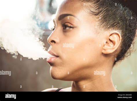 Profile Of A Black Girl Smoking From Her Mouth And Blowing The Smoke