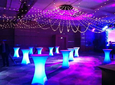 An Indoor Event With Blue And Purple Lights On The Ceiling Tables And