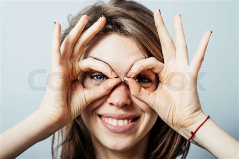 Young Happy Woman Holding Her Hands Over Her Eyes As Glasses And