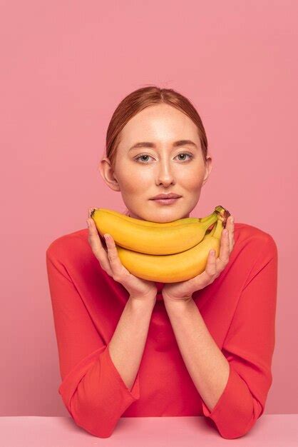 free photo redhead woman posing next to bananas