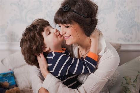 El niño besa a su mamá y la abraza mujer joven feliz divertirse con