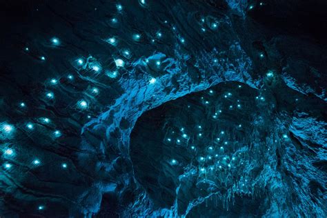 The Inside Of A Cave Lit Up With Blue Lights And Small White Dots On It
