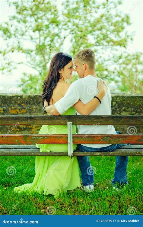 Attractive The Guy With The Girl Sit And Embrace On A Bench Stock Image