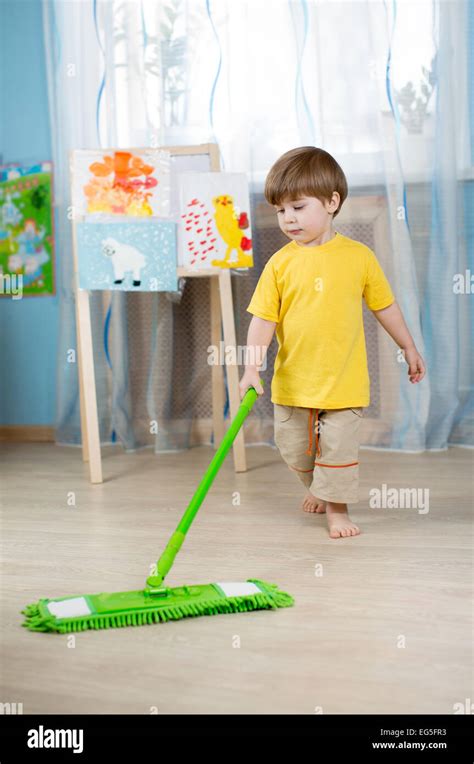 Little Boy Cleaning The Apartment Washing Floor With Mop Stock Photo