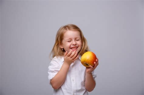 Premium Photo Cute Little Girl Holding An Apple On A White Background