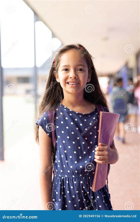 Vertical Portrait Of Smiling Caucasian Schoolgirl In Elementary School