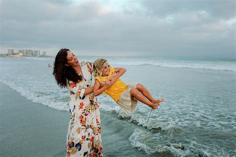 Happy Mother Spinning Daughter At Beach Against Cloudy Sky Photograph By Cavan Images