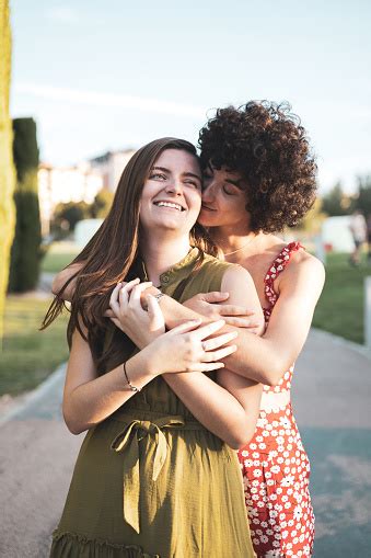 A Couple Of Lesbian Girls Hug Each Other From Behind While Kissing Each Other On The Cheek Lgtbi