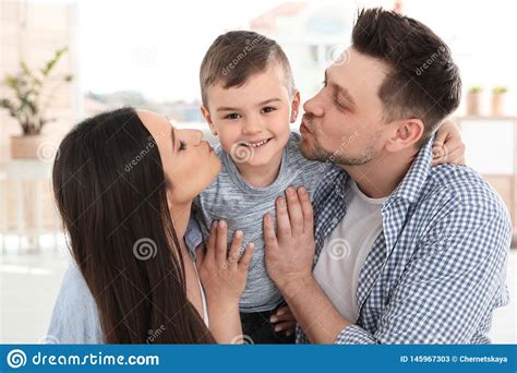 Padres Felices Que Besan A Su Hijo Tiempo De La Familia Imagen De