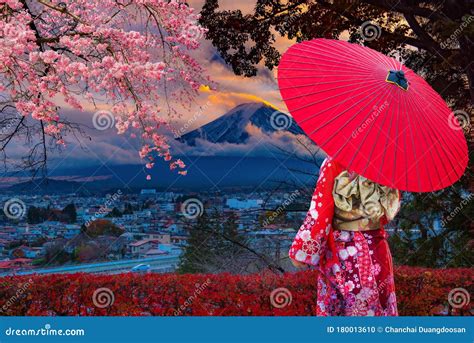 Asian Women Wear Japanese Kimonos Holding A Red Umbrella At Mount Fuji