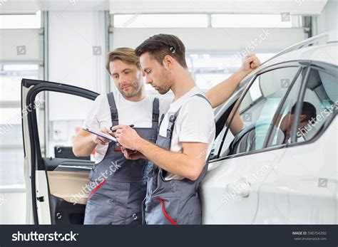 Automobile Mechanics Checking Checklist While Standing Foto De Stock