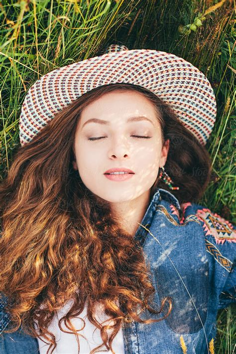 Sensual Portrait Of A Beautiful Woman With Hat Laying On The Grass