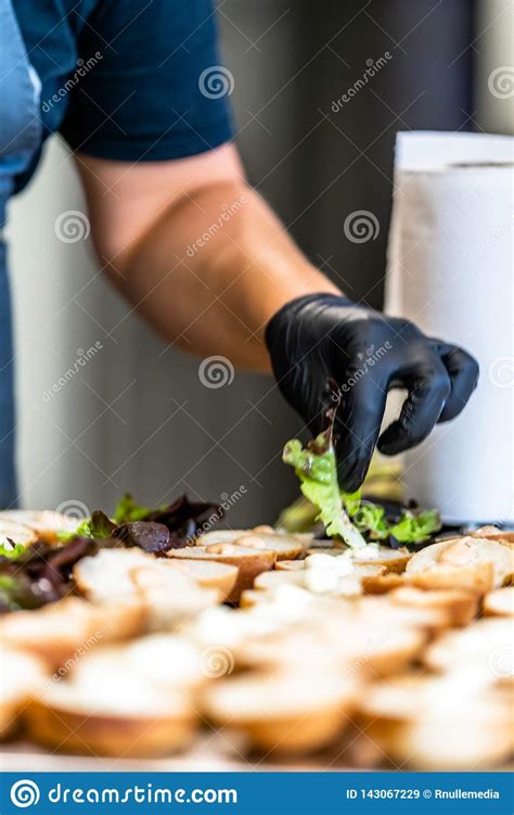 Female Chef Putting Ingredients Of Burgers On A Sliced