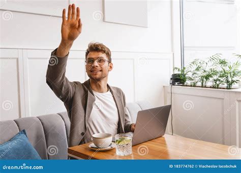 Handsome Young Man Saying Hello To Friend In Cafe Stock Photo Image