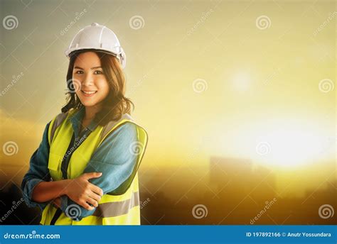 Female Civil Engineer With Safety Equipment With Sunset City Golden Sky