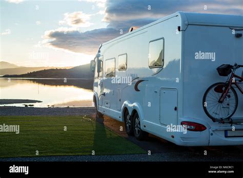 Large Camper Van Parking Near The Water At A Campsite For Motorhomes
