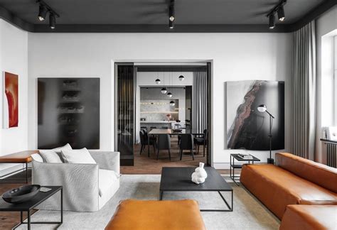 Modern spacious loft style living room with emerald leather furniture, big windows. 2 Sophisticated Industrial Style Homes