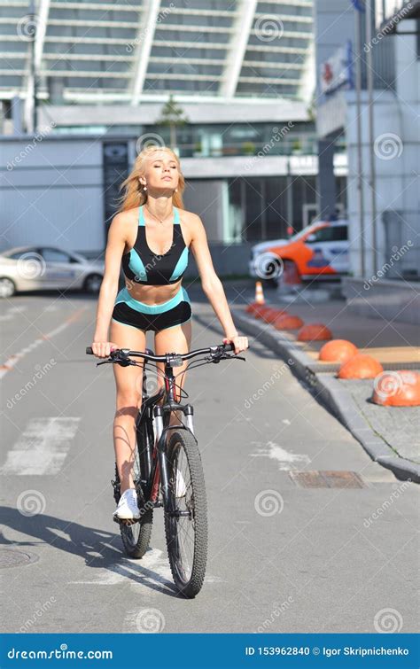 Une Fille Sexy Avec De Gros Seins Fait Du Vélo En Milieu Urbain Photo Stock Image Du Pattes