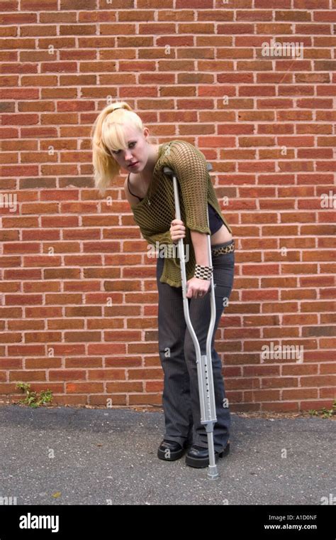 Teen Girl Standing On A Crutch Next To A Brick Wall Model Released