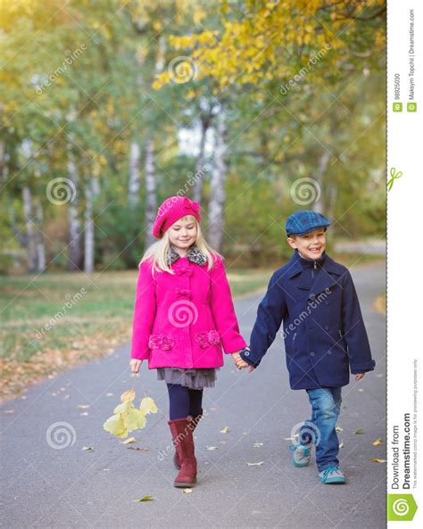 Children Walking In Beautiful Autumn Park On Warm Sunny