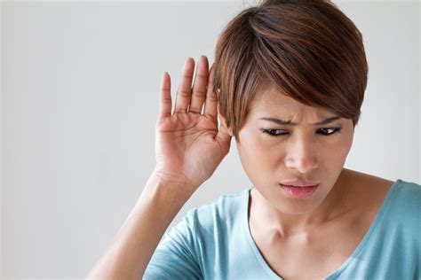 woman suffers from hearing impairment, hard of hearing ...