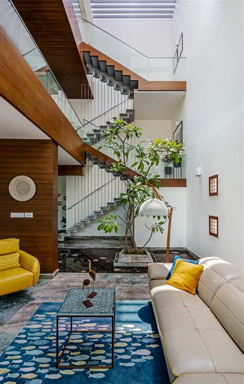 Staircase Under A Skylight Next To A Double Height Living Room With An