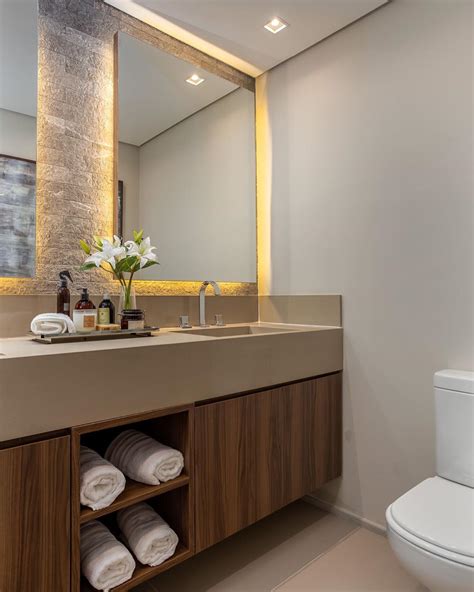 Banheiro Bege E Amadeirado Com Parede De Pedras E Espelhos Retroiluminados Decor Salteado
