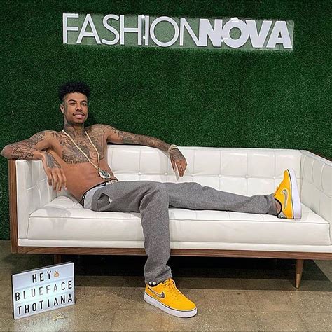 A Man Laying On Top Of A White Couch Next To A Sign That Says Fashionnovaa