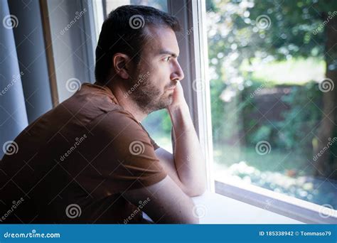 Thoughtful Depressed Guy Portrait Looking Out The Window Stock Photo