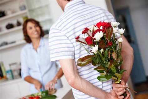 Keeping Their Love Fresh A Husband Surprising His Wife With A Bunch Of Flowers At Home Stock