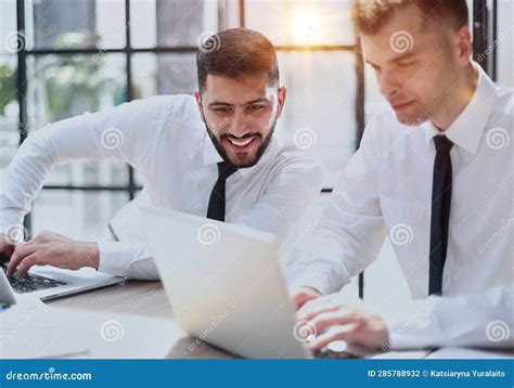 Two Happy Men Working Together On A New Business Project Stock Photo
