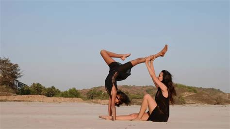 Mom Trains A Teen Daughter To Perform Acrobatic Element On The Beach By