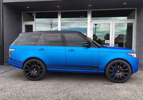 A Blue Range Rover Parked In Front Of A Building