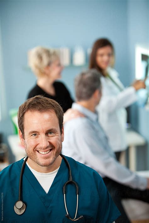 Exam Room Male Nurse With Patients Behind By Stocksy Contributor
