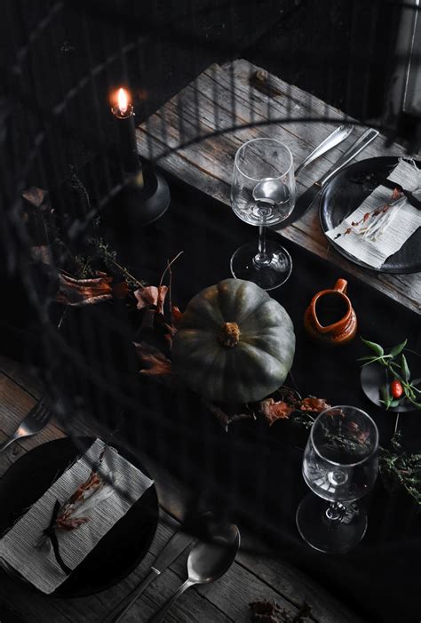 Tinted glass goblets, table linen in different shades of orange, wooden details, and some pieces (like table runners or flatware) in the contrasting purple or black are a winning combination! Conjure up a Dramatic Halloween Table Setting