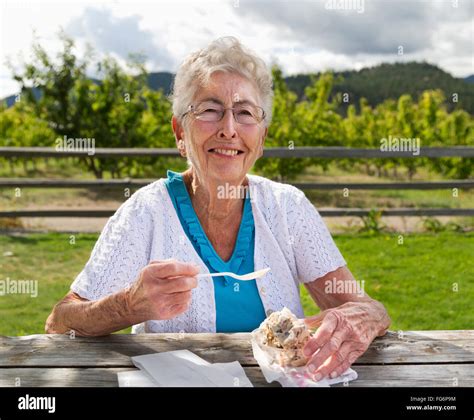 a mature woman eating ice cream outside an ice cream shop summerland british columbia canada