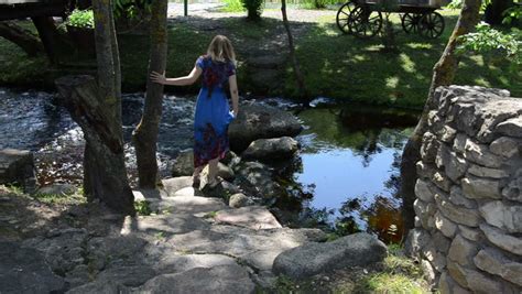 Young Girl Holds A Dress Skirt And Wade Barefoot Pebble Creek Sunny