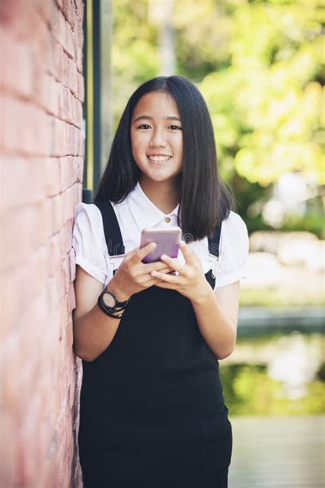 Beautiful Asian Teenager Toothy Smiling Face Using Smarphone In Stock Photo Image Of Asian