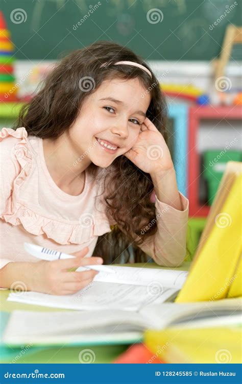 Portrait Of A Schoolgirl Doing Homework In Classroom Stock Image