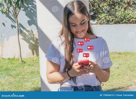 Happy Young Woman Uses Her Cell Phone While Receiving Social Media Notifications Editorial Image