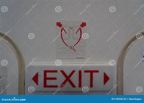 Exit Sign On An Emergency Exit Door In An Airplane Shows The Way How Do