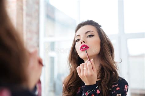Seductive Woman Applying Red Lipstick To Lips Looking In Mirror Stock Image Image Of Creating