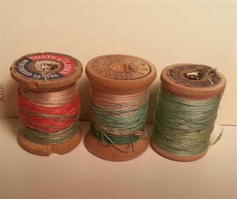 Three Spools Of Thread Sitting Next To Each Other On Top Of A Table