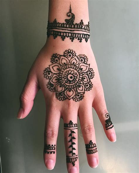 A Woman S Hand With Henna Tattoos On It