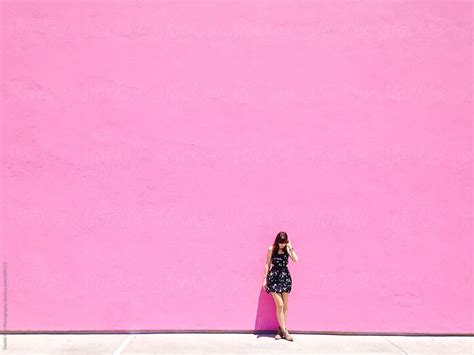 Girl Standing Up Against Bright Pink Wall Stocksy United
