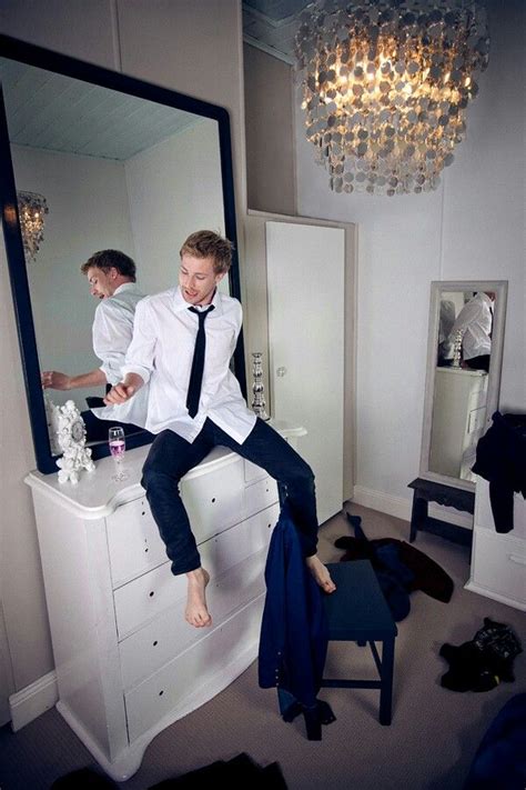 Two Men Sitting On Top Of A Dresser In Front Of A Mirror And Dressing Table