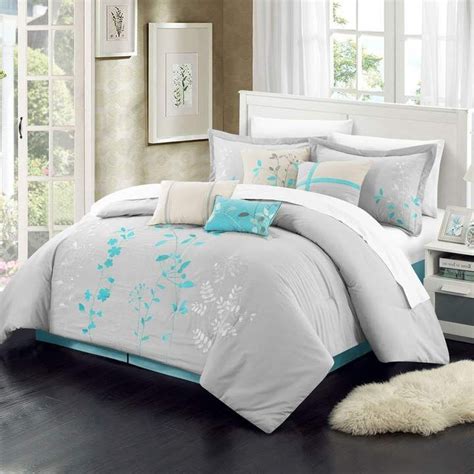 A Bed With White And Blue Comforters In A Room