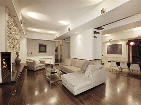 Open Plan Living Room Using White Colours With Floorboards And Bi Fold