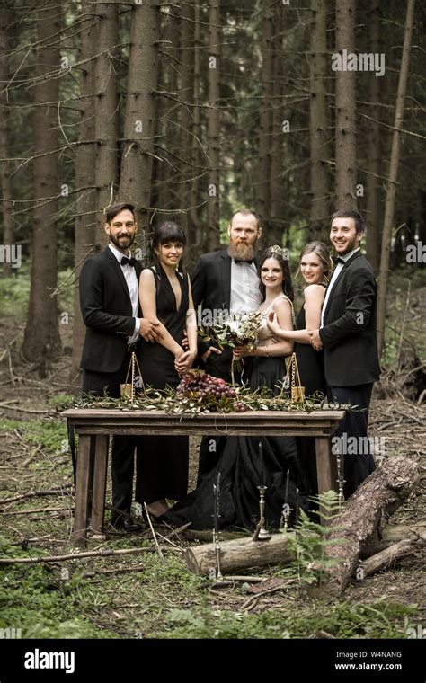 Portrait Of The Newlyweds And Guests At The Picnic Table Stock Photo